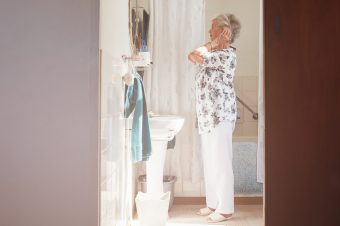 mature women over 50 standing in front of the mirror getting ready