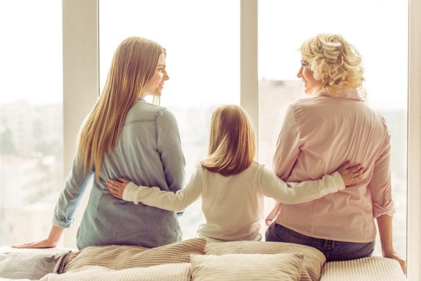 Three people sitting near a bright window