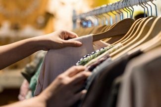 Woman shopping for clothes on a rack at the store