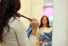 Women looking in mirror holding a blue dress