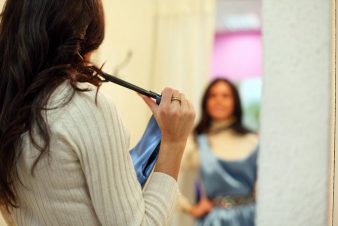 Women looking in mirror holding a blue dress