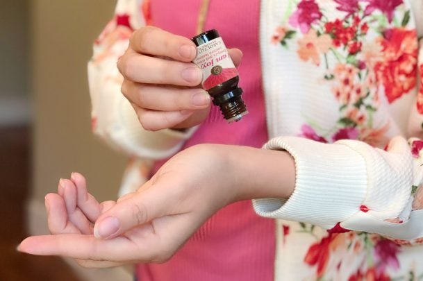 Woman putting essential oil on her wrist