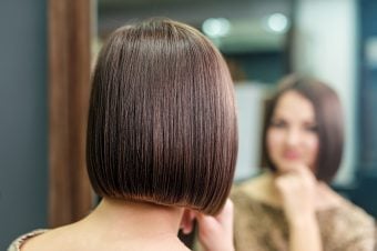 Woman with bob haircut looking at reflection in mirror