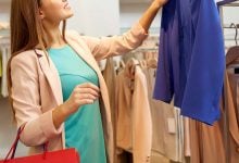 Woman choosing blue jacket at store