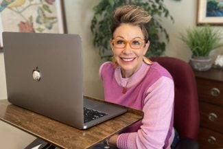 Carol in front of her laptop - how to look great on zoom