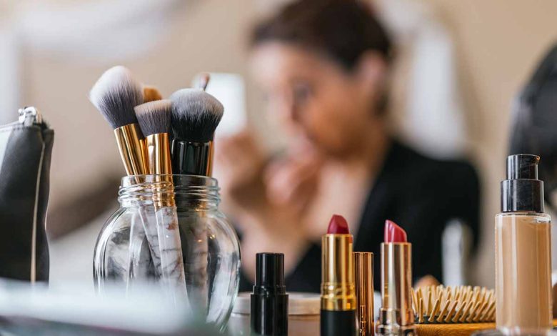 Woman putting on makeup with all her products in front